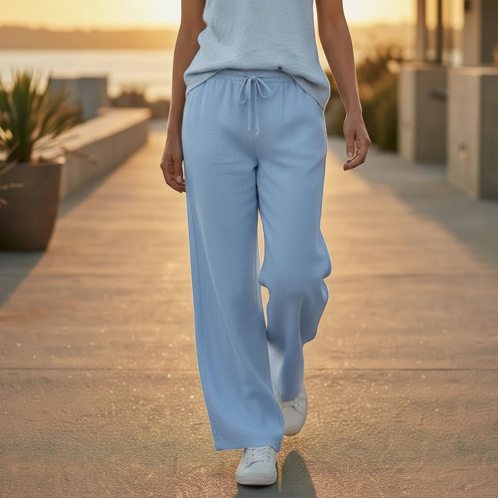 Femmes de pilotes Pantalon large bleu ciel en tissu fluide, taille élastique avec liens ornés de perles en bois argenté.