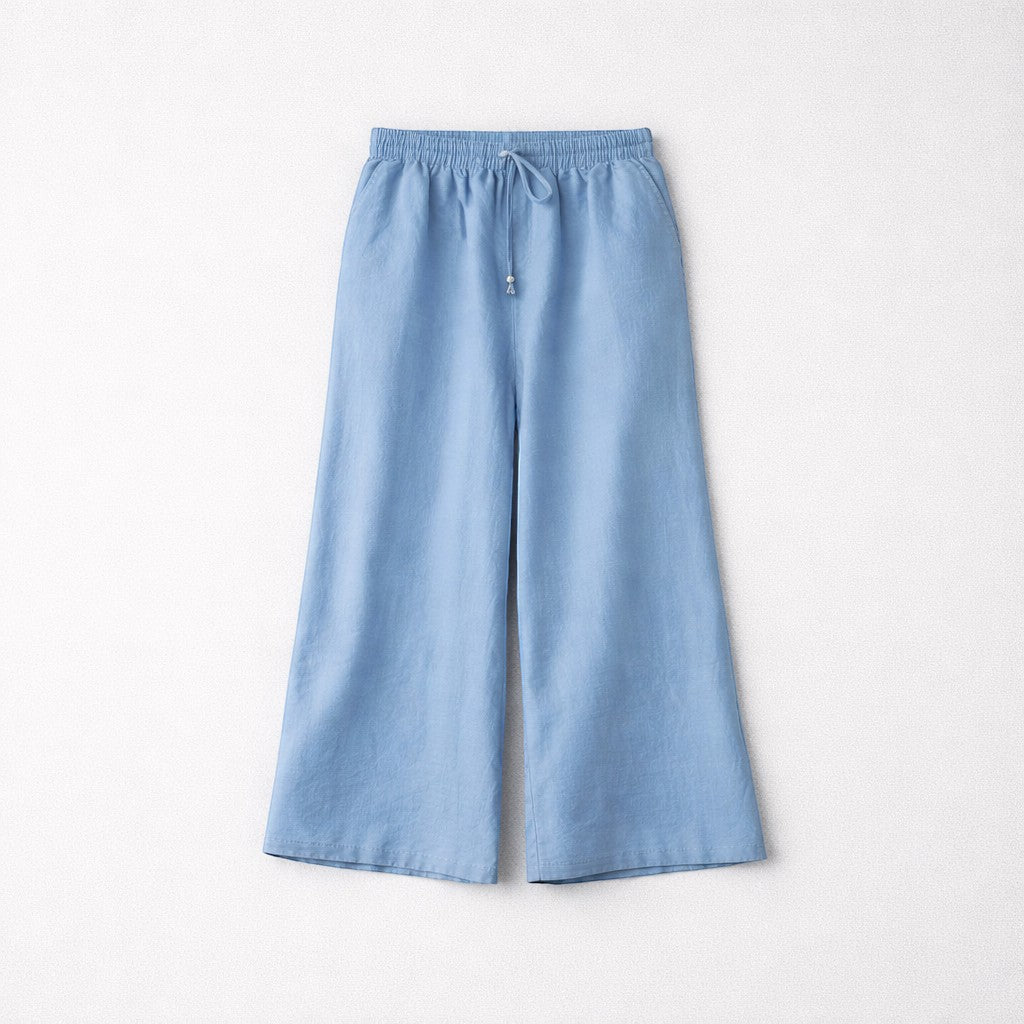 Femmes de pilotes Pantalon large bleu clair en tissu fluide, taille élastique avec cordon et perles en bois argenté.